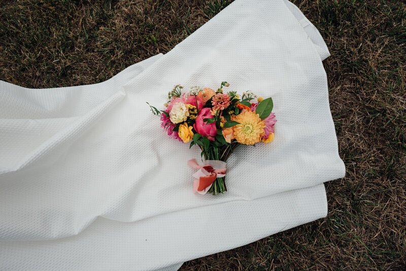 Bride's bouquet on wedding dress by 35mm film wedding photographer Noble Photo Co