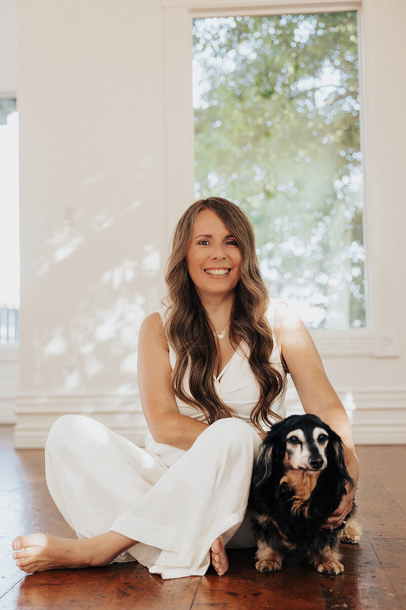 Patty sitting on the floor with her dachshund