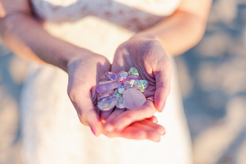 Hands holding purple and white gems
