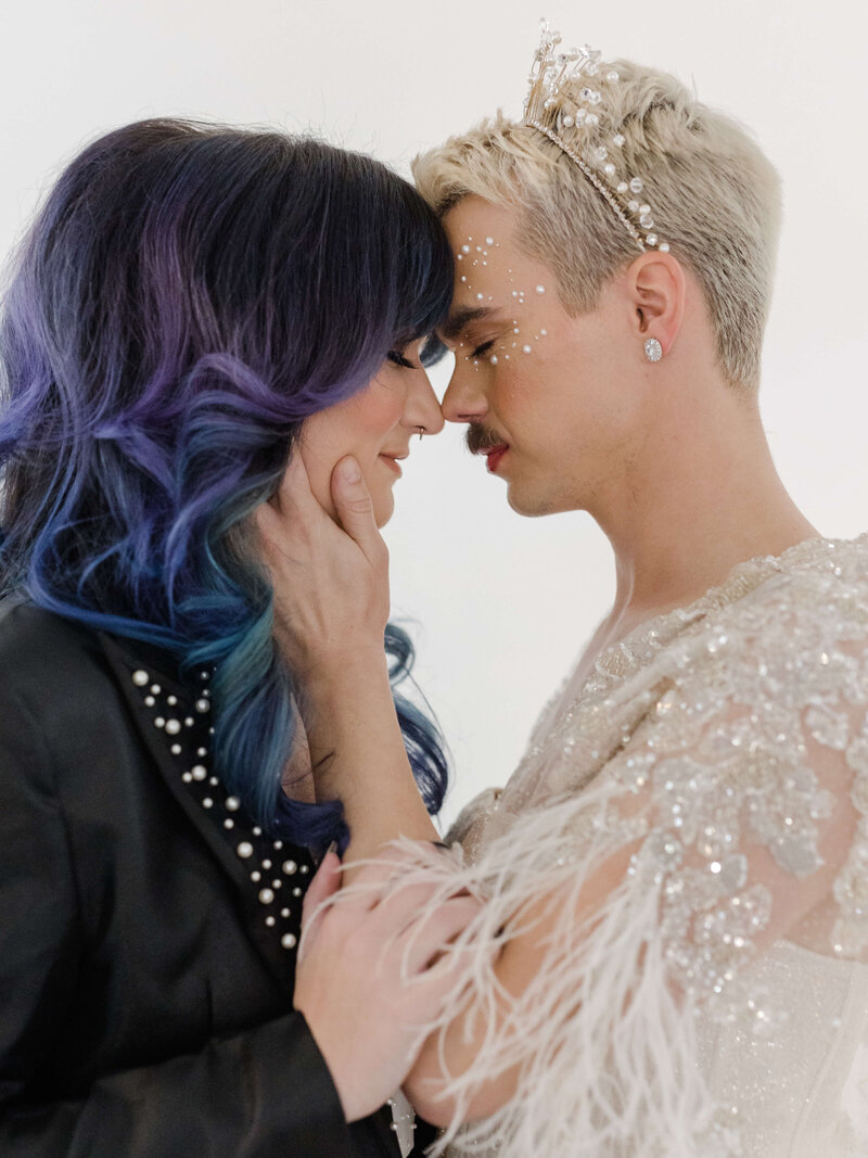 LGBTQ+ couple kissing and wearing wedding attire at their elopement