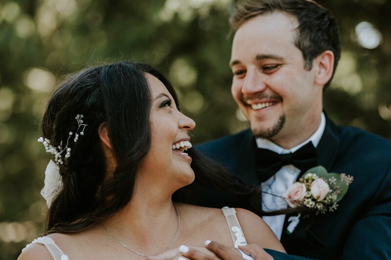 Close up of bride and groom laughing.