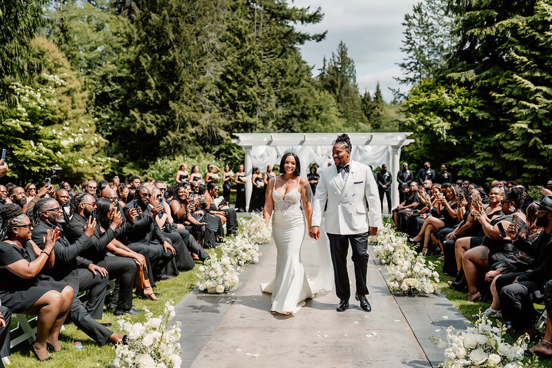 a bride and groom walking down the aisle after they got married looking very happy