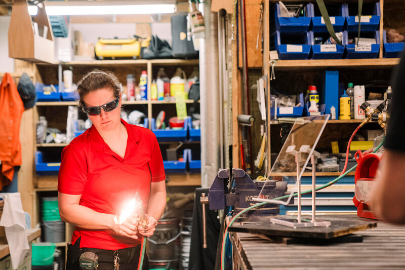 a member of a museum exhibits team lights a welding torch