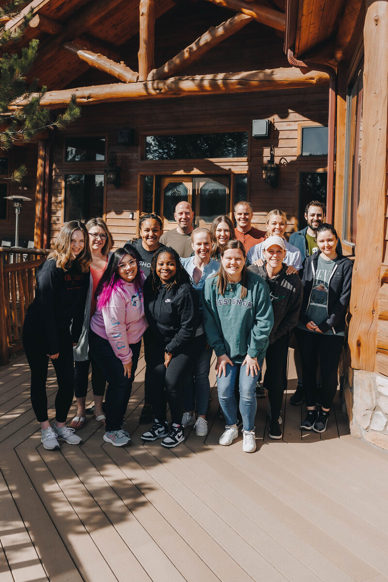 A group of women sit around a dining table smiling. 