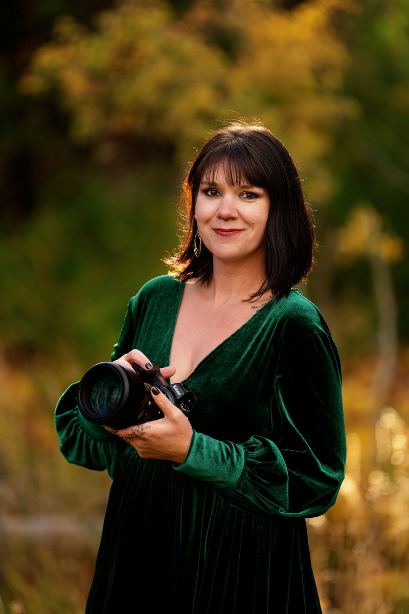 Brown haired lady sitting in a chair smiling at camera