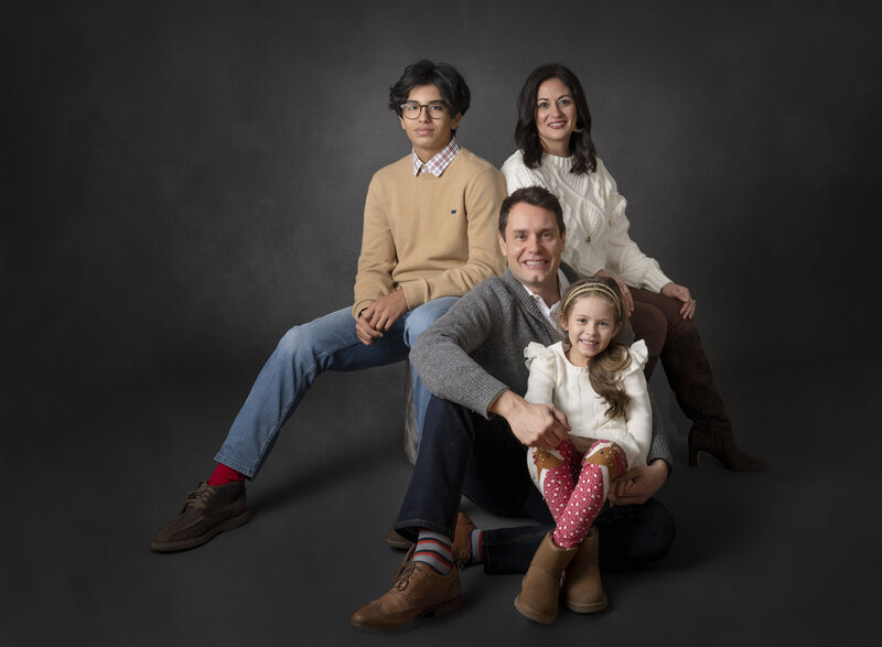 Family of four on dark gray background