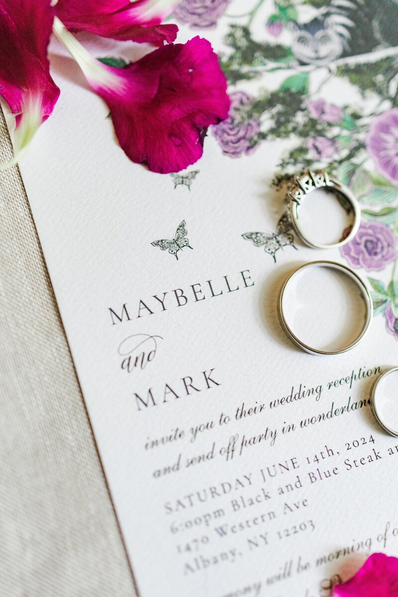 wedding invitation with rings and flowers during wedding photo session in capital region