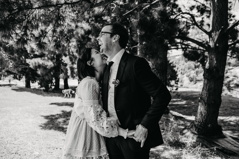 black and white image of bride and groom laughing and hugging each other