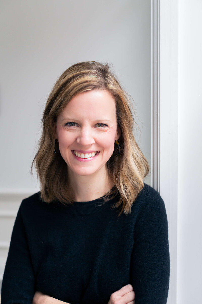 woman smiling for the camera wearing a black long sleeve top