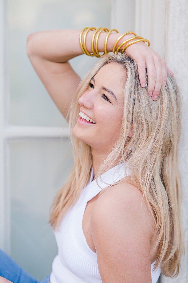 a girl smiling with her hand in her hair