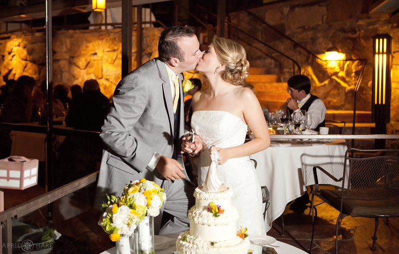 Bride and Groom Kiss after cutting the cake at their outdoor Flagstaff House Intimate Wedding in Boulder