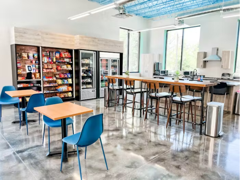 Modern office micro market setup with snack shelves, drink coolers, and seating area, serviced by Treehouse Vending