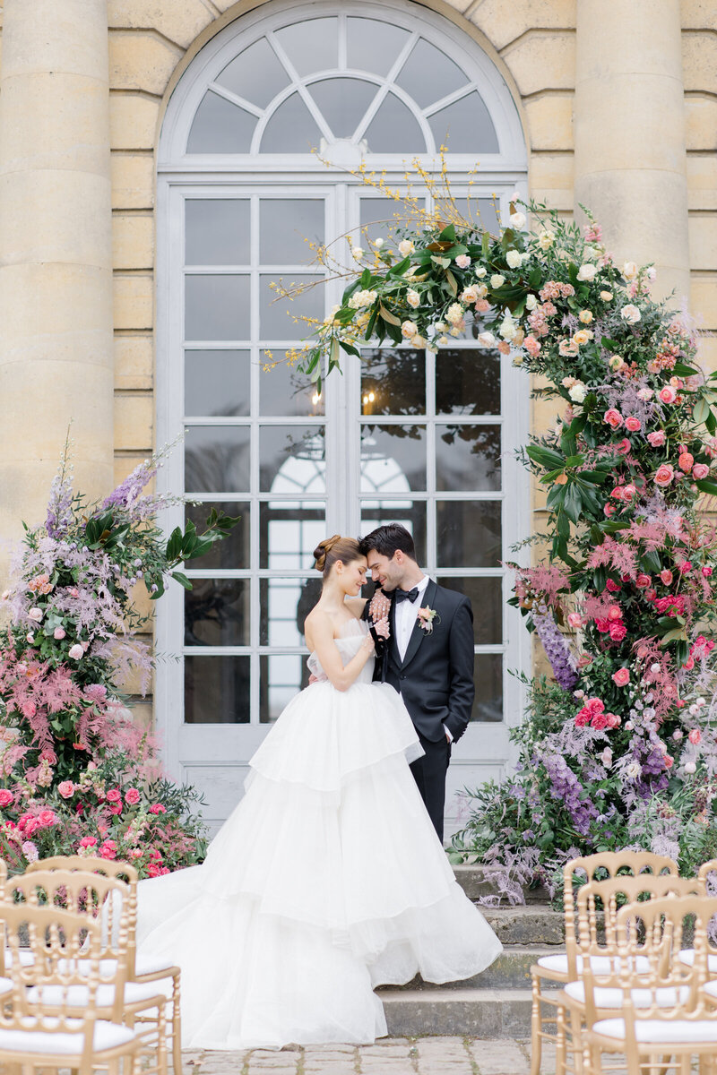 Outdoor wedding ceremony with ombre rainbow flowers