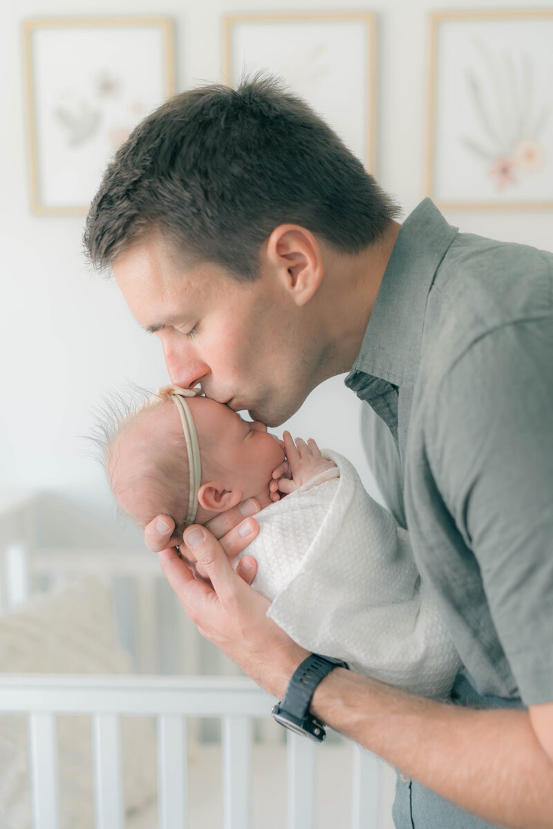 A newborn cradled in soft textures during an in-home session in South Jordan, Utah.