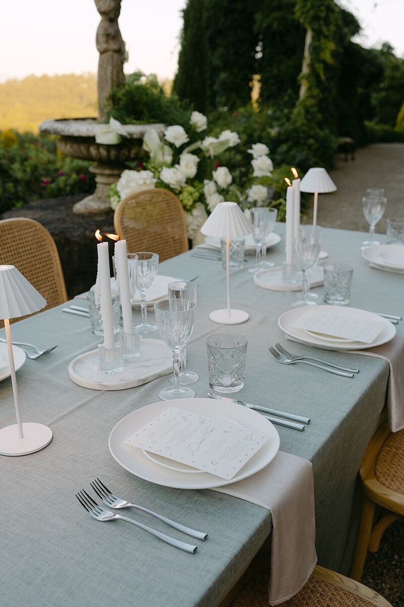 Table setting with green and white dinnerware and candles