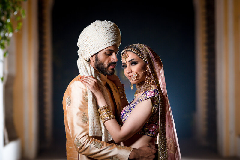 indian couple in pink and white cultural attire smiling
