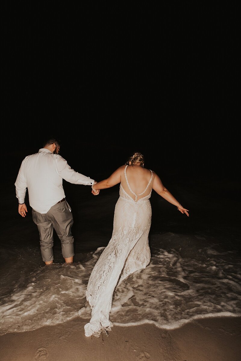 Couple popping champagne at night after their St. Augustine elopement