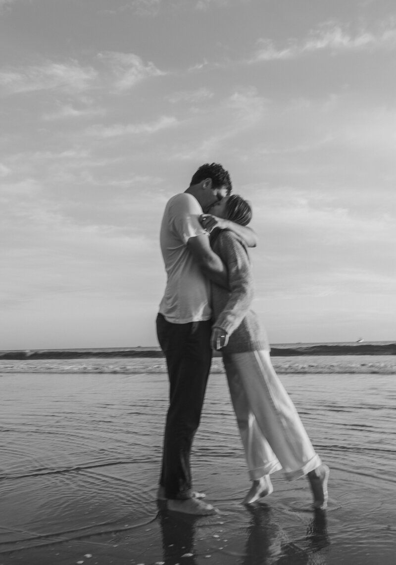 couple kissing and holding each other on the beach