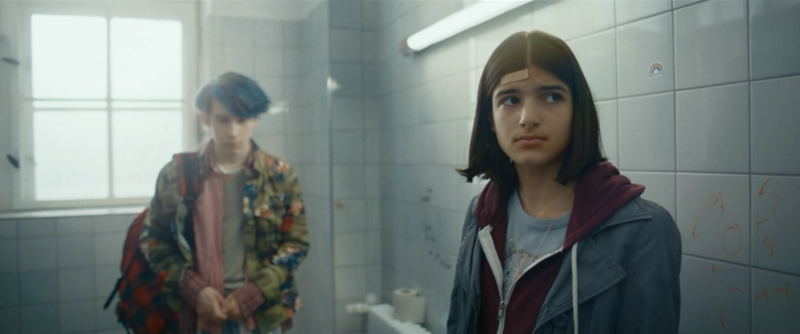 Two teens facing off in a classroom setting, caught in dramatic mid-action.