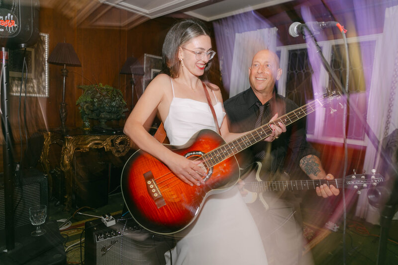 bride playing guitar at wedding