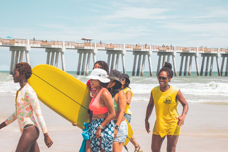 A group of female surfers support each other during a competition