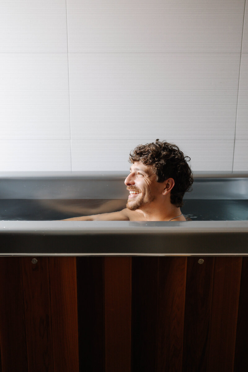 Woman relaxing in cold plunge at Vitalis wellness studio for muscle recovery and mental clarity