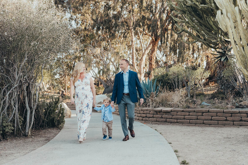 A family walks together in Balboa Park during their maternity photography session