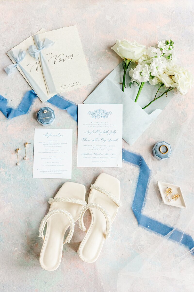 a flat lay of blue and white wedding memorabilia