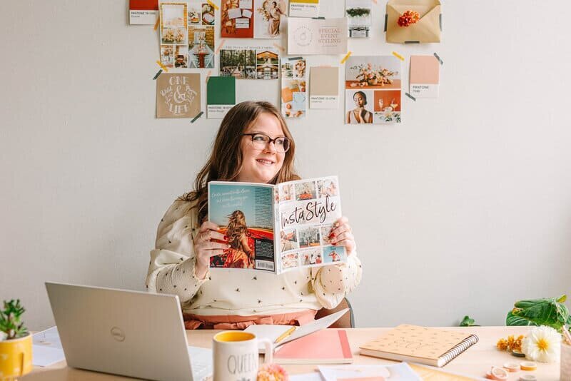 Katelynn sitting at a desk holding a magazine