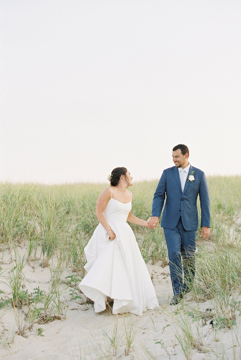 newlyweds in the sand dunes and sea grass at Chatham Beach and Tennis Club wedding