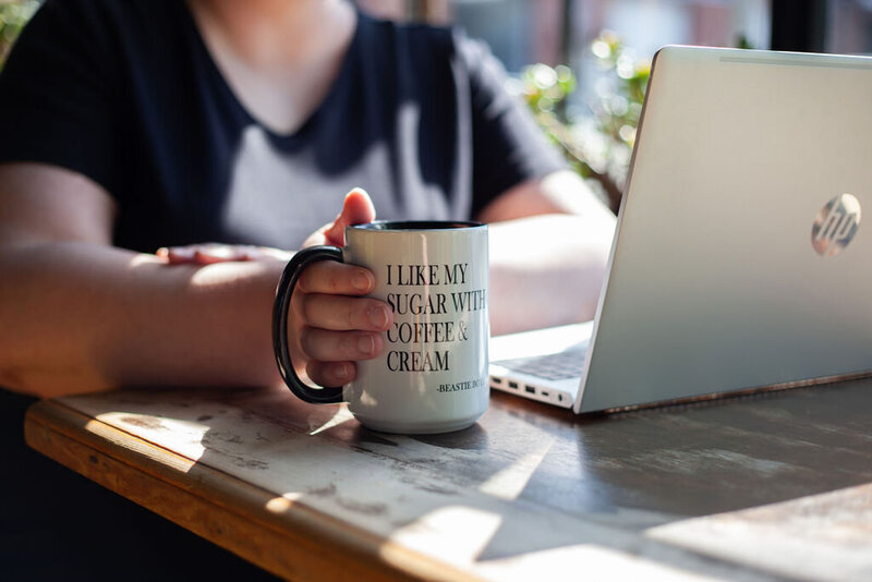 Closeup of Kristen's mug, which says "I like my sugar with coffee & cream--Beastie Boys."