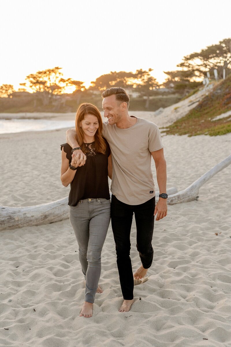 A man and woman on the beach together smiing