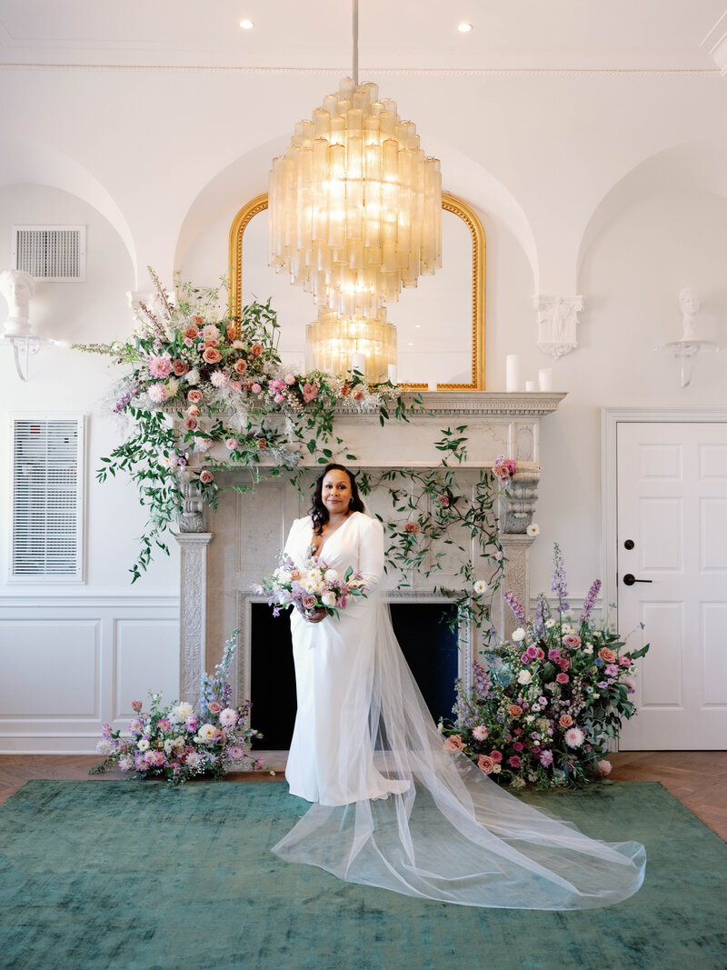 Bride standing in front of fireplace at The Riggs Hotel