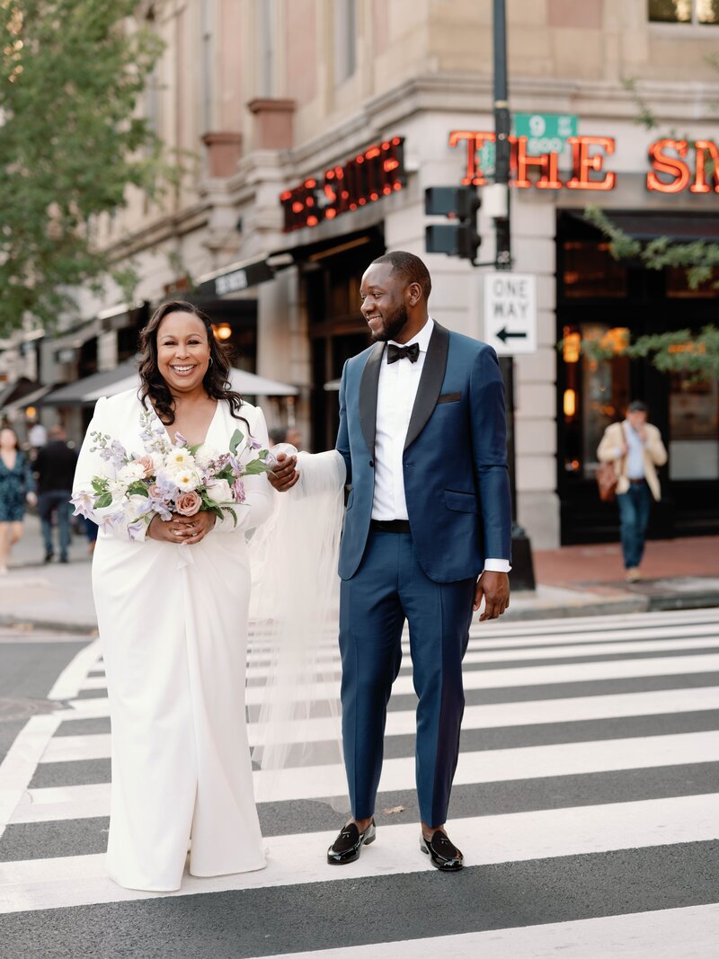 Bride and groom smiling in the road by wedding venue in Washington DC