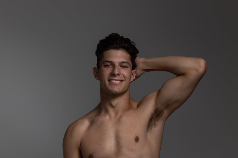 shirtless man with muscles smiling at camera