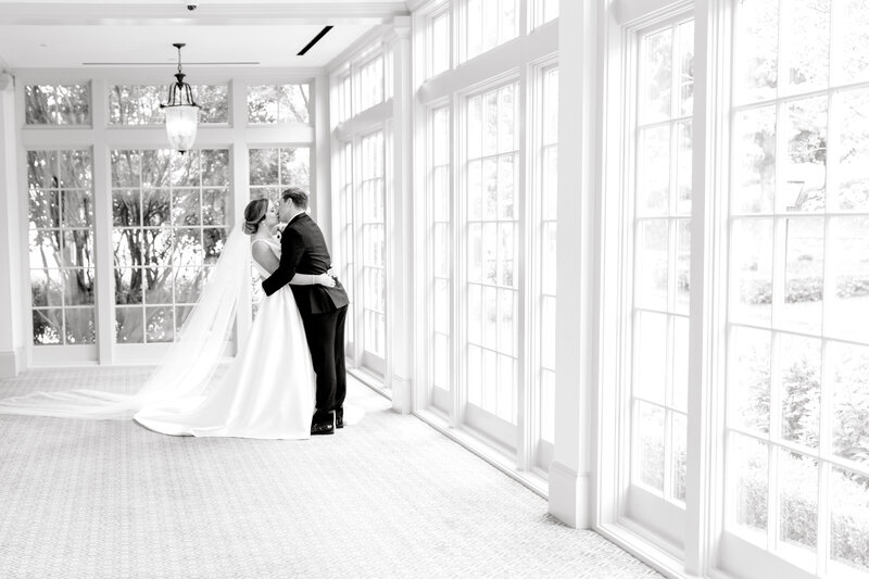 groom dipping bride by windows