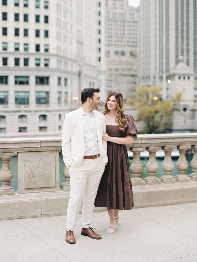 Bride and groom smiling at one another in city photographed by Chicago and destination editorial wedding photographer Arielle Peters