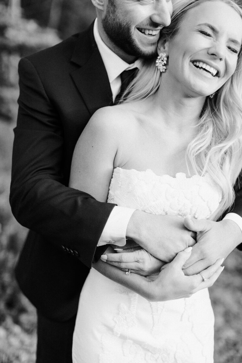 Portrait of a bride laughing and being hugged from behind by her groom at Donovan Pavilion in Vail Colorado.