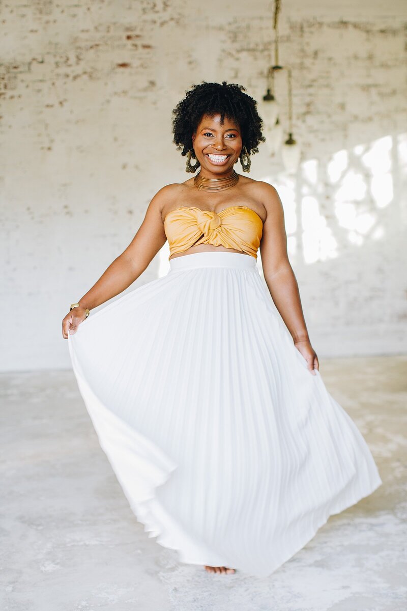 Yvette Henry dancing in white skirt and bandeau top.