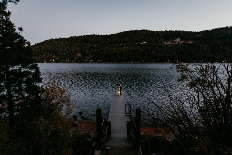 Couple dancing on a rocky overlook at Donner Summit during their Lake Tahoe elopement, surrounded by mountain views and soft sunset light over Donner Lake.