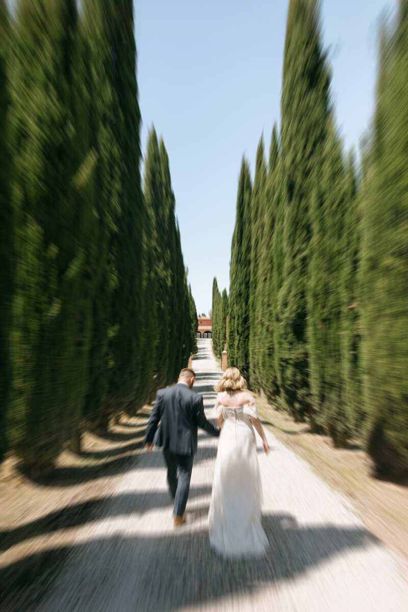 Bride and groom holding hands in St. Mark's Square in Venice, Italy