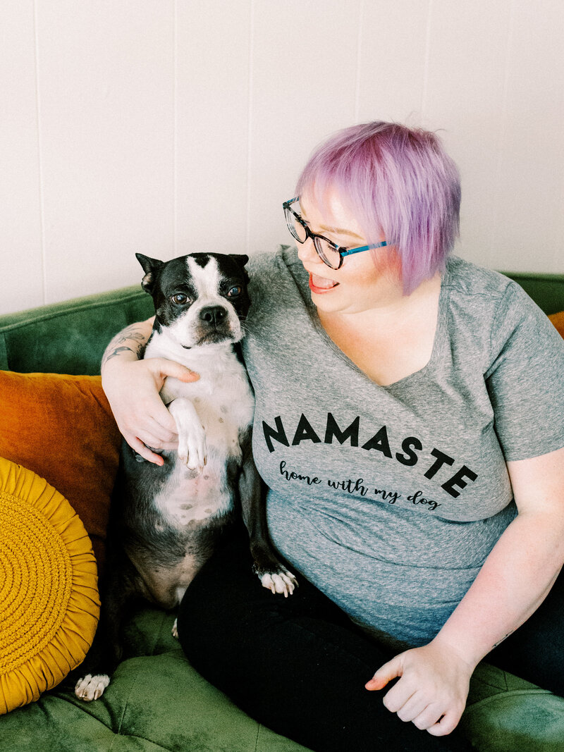photographer with lavender hair smiling at her dog