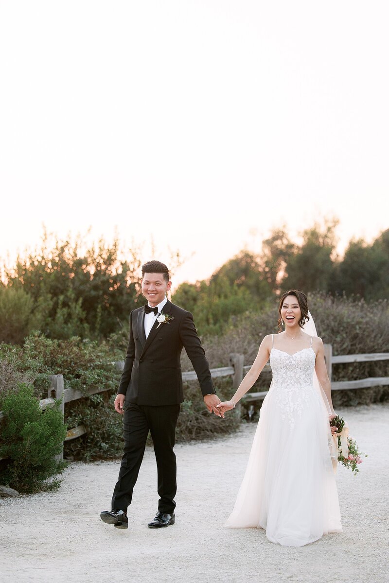 Bride and groom kiss at the end of a dock over water in Santa Ynez, California