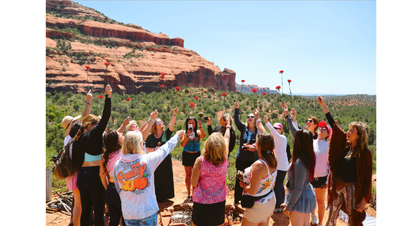 dana haines facilitating a special flower rose ceremony by a fire in sedona, arizona for a womens wellness retreat