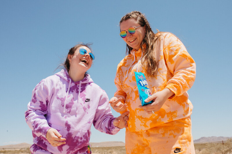 two friends hold candy in the desert