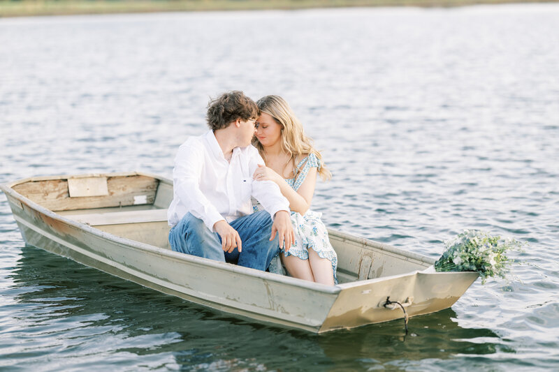 engaged couple touching foreheads while riding in a small boat