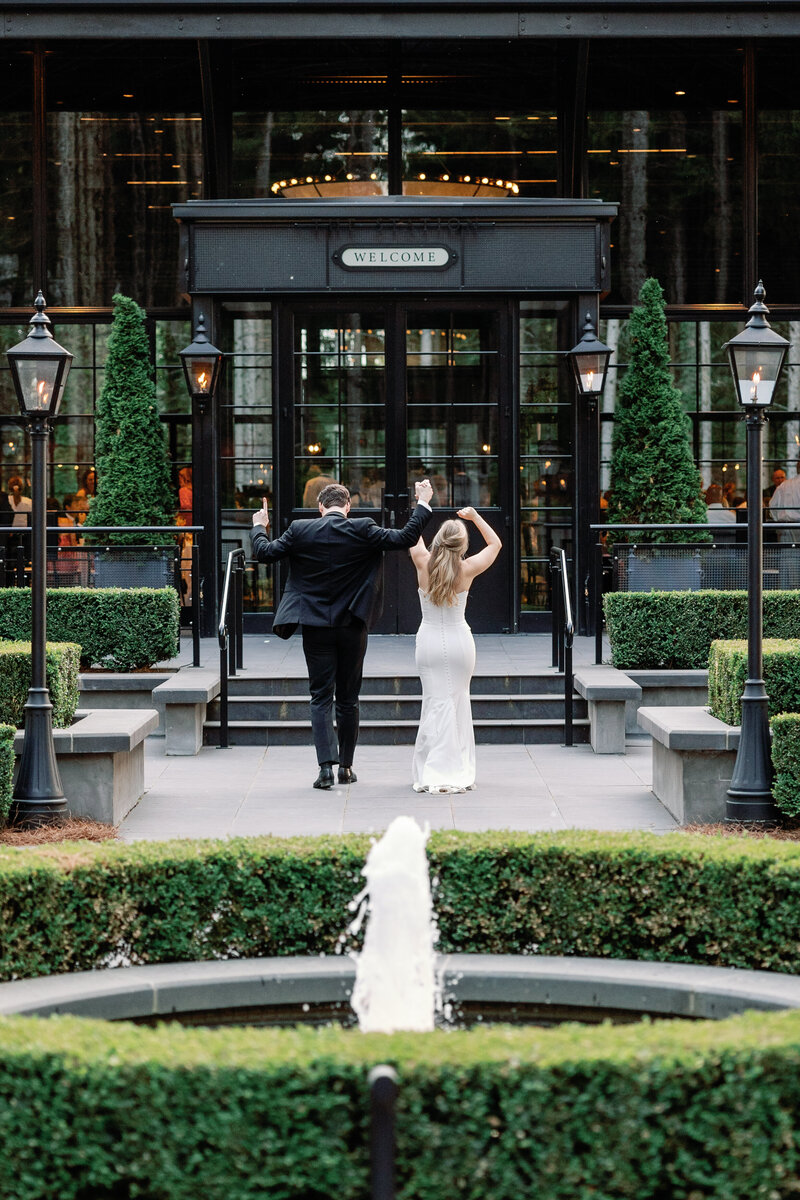 Bride and groom celebrating their small wedding and elopement at Shepherd's Hollow Golf Club in Clarkston Michigan. They are on the patio by the fountain.