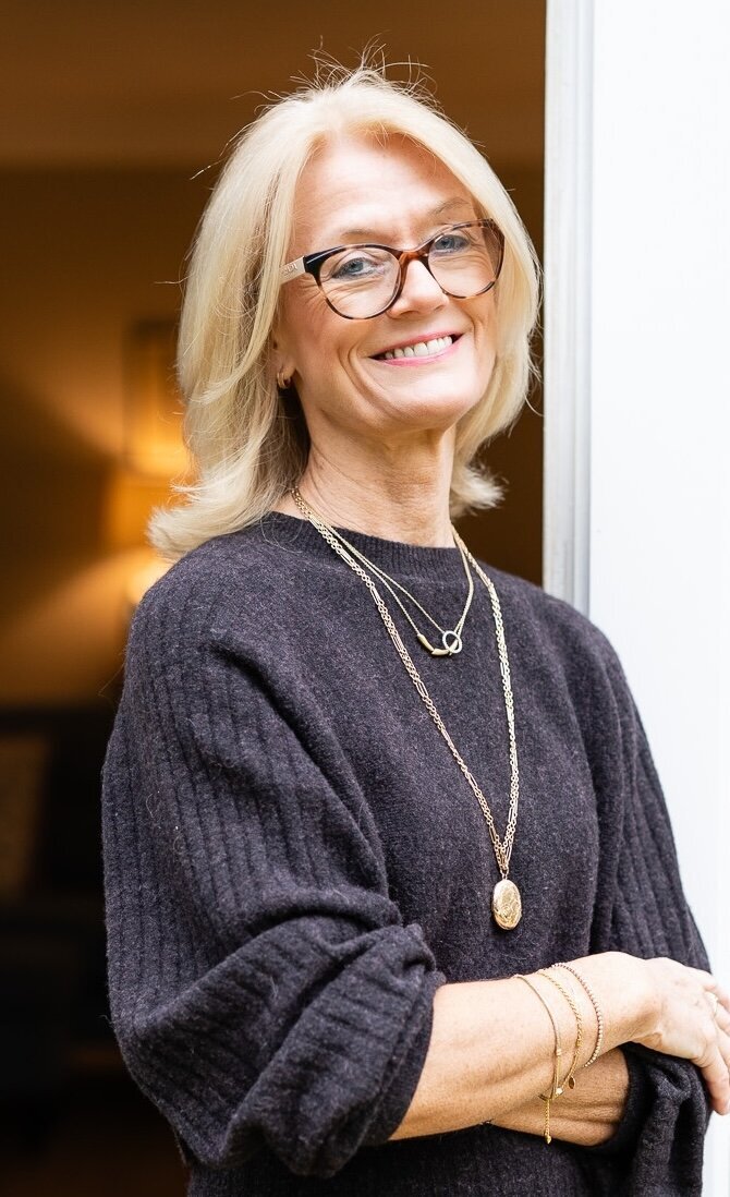 woman with blond hair in sweather dress smiling