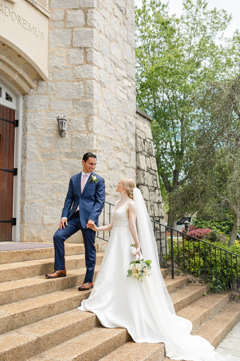 bride and groom walking on the steps of a church