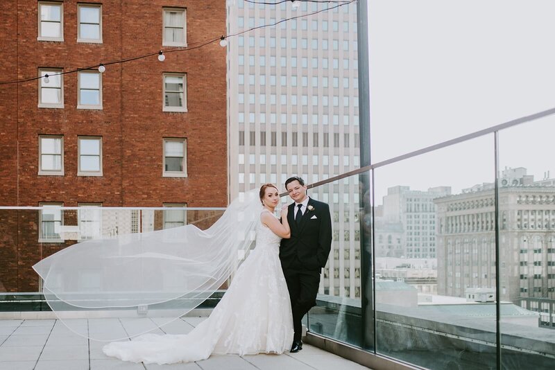 Bride and groom post together on rooftop